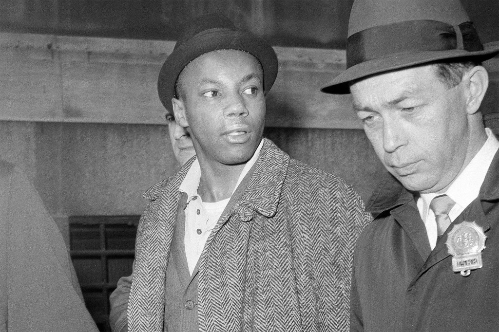 Aziz under arrest for allegedly killing Malcolm X. The city will pay $26 million and New York state will pay $10 million for the wrongful conviction.