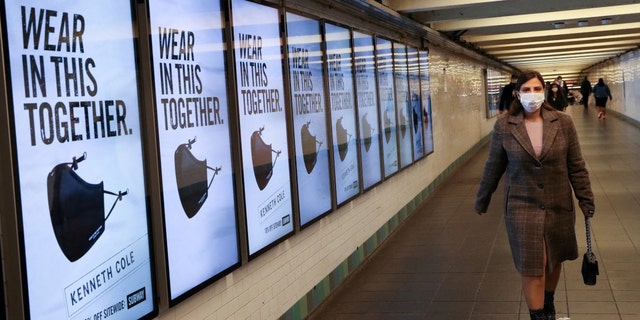 A subway rider passes ads for face masks at Times Square station in Manhattan, as the global outbreak of the coronavirus disease (COVID-19) continues, in New York City, U.S., November 14, 2020. 