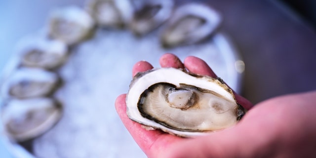 Ben Wolven, as know as Oyster Wulff, is shucking oysters outside of Forget Me Not bar in Cherry Creek in Denver, Colorado on Friday, March 11, 2022. 