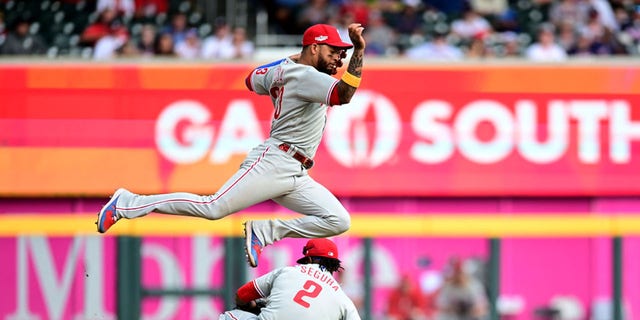 Jean Segura (2) of the Philadelphia Phillies fields a ground ball against the Atlanta Braves during the ninth inning in Game 1 of the National League Division Series at Truist Park Oct. 11, 2022, in Atlanta.