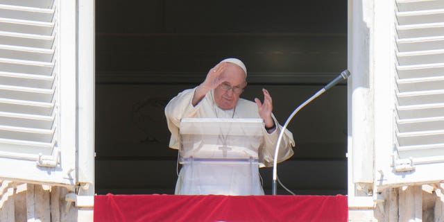 Pope Francis waves during the Angelus noon prayer from the window of his studio overlooking St. Peter's Square, at the Vatican, Sunday, Oct. 2, 2022. 