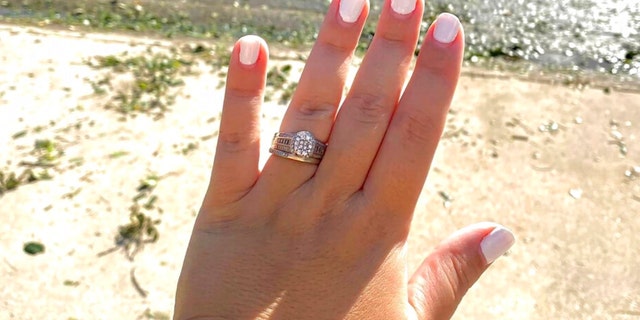 In this undated photo provided by Ashley Garner, Garner shows off her wedding ring that was found lying in a brush pile after Hurricane Ian passed through the area, in Fort Myers, Florida.