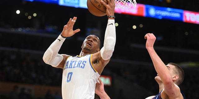 Los Angeles Lakers guard Russell Westbrook, #0, goes to the basket against Denver Nuggets center Nikola Jokic, #15, during the first half of an NBA basketball game Sunday, Oct. 30, 2022, in Los Angeles.