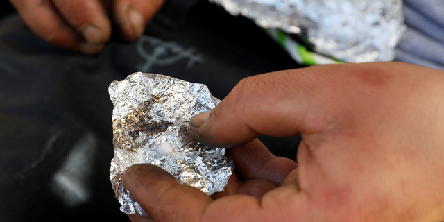 A man living on the streets displays what he says is the synthetic drug fentanyl, across the street from where San Francisco mayor London Breed just held a news conference introducing legislation in curbing the rise of deadly overdoses in the city, at the Tenderloin section of San Francisco, California, U.S., February 27, 2020. REUTERS/Shannon Stapleton