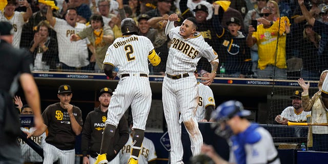 San Diego Padres' Trent Grisham (2) celebrates with teammate Manny Machado after hitting a home run during the fourth inning in Game 3 of a baseball NL Division Series against the Los Angeles Dodgers, Friday, Oct. 14, 2022, in San Diego.