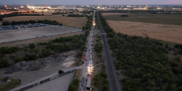 In this aerial view, members of law enforcement investigate the deaths of 53 migrants found in the back of a tractor trailer on June 27, 2022 in San Antonio, Texas. 