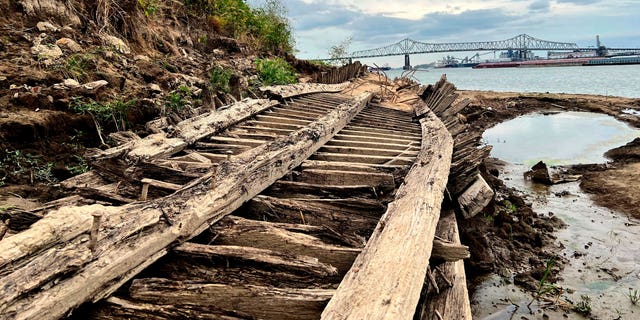 The remains of a ship lay on the banks of the Mississippi River in Baton Rouge, La., on Monday, Oct. 17, 2022, after recently being revealed due to the low water level. The ship, which archaeologists believe to be a ferry that sunk in the late 1800s to early 1900s, was spotted by a Baton Rouge resident walking along the shore earlier this month. (AP Photo/Sara Cline)