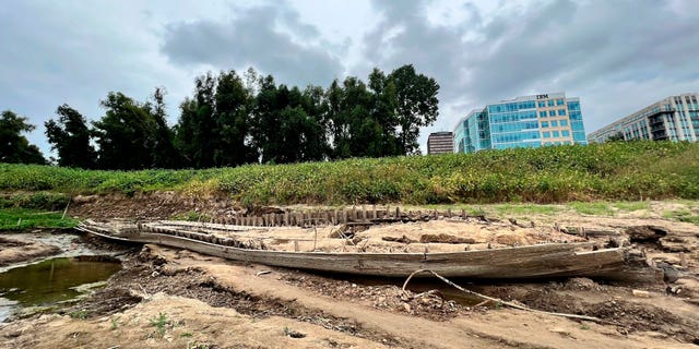 The remains of a ship lay on the banks of the Mississippi River in Baton Rouge, La., on Monday, Oct. 17, 2022, after recently being revealed due to the low water level. The ship, which archaeologists believe to be a ferry that sunk in the late 1800s to early 1900s, was spotted by a Baton Rouge resident walking along the shore earlier this month. (AP Photo/Sara Cline)