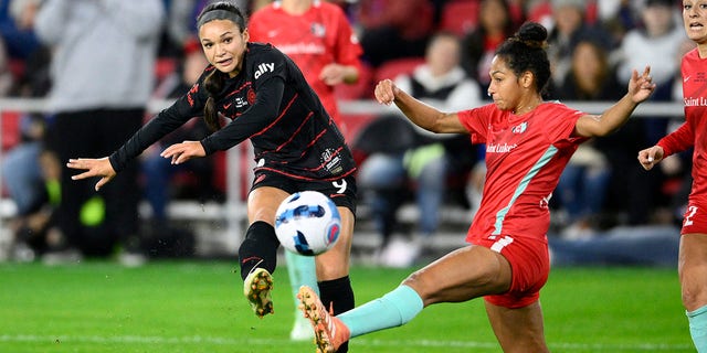 Portland Thorns forward Sophia Smith, left, kicks the ball against Kansas City Current defender Addisyn Merrick during the NWSL championship match, Saturday, Oct. 29, 2022, in Washington.