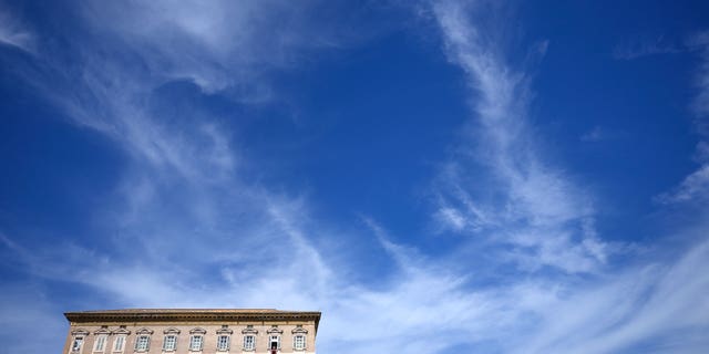 Pope Francis, second window from right, reads a message during the Angelus noon prayer from the window of his studio overlooking St.Peter's Square, at the Vatican, Sunday, Oct. 2, 2022. 