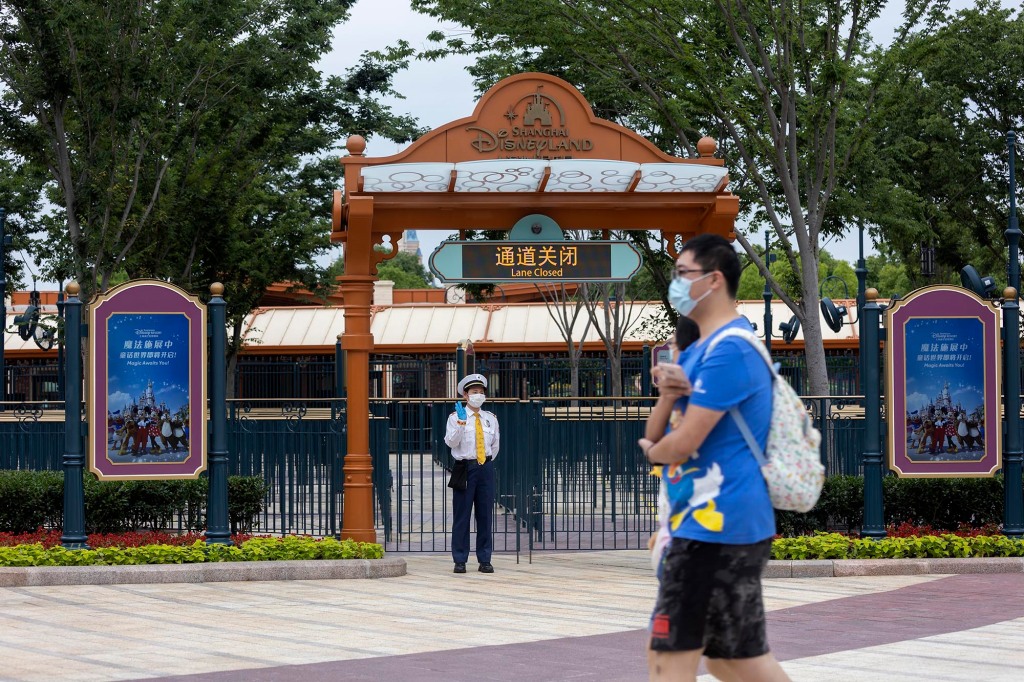 A staff member greets spectators at the Disney resort on June 10, 2022 in Shanghai, China. Shanghai Disney Resort is resuming partial operations, with reduced capacity and opening hours, as COVID-19 cases ease in the city in June.