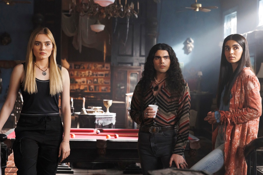  Meg Donnelly as Mary,  Jojo Fleites as Carlos and Nida Khurshid as Latika on "The Winchesters" stand in a line in a room. 