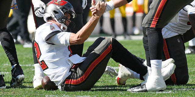 Tampa Bay Buccaneers quarterback Tom Brady is helped up after a play against the Pittsburgh Steelers in Pittsburgh on Oct. 16, 2022.