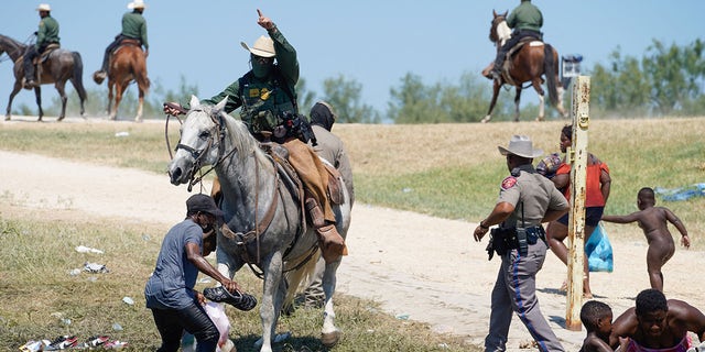 A United States Border Patrol agent on horseback tries to stop a Haitian migrant from entering an encampment on the banks of the Rio Grande near the Acuna Del Rio International Bridge in Del Rio, Texas on Sept. 19, 2021.