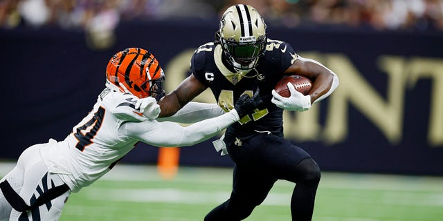 Alvin Kamara #41 of the New Orleans Saints breaks a tackle from Vonn Bell #24 of the Cincinnati Bengals during the third quarter at Caesars Superdome on October 16, 2022 in New Orleans, Louisiana.