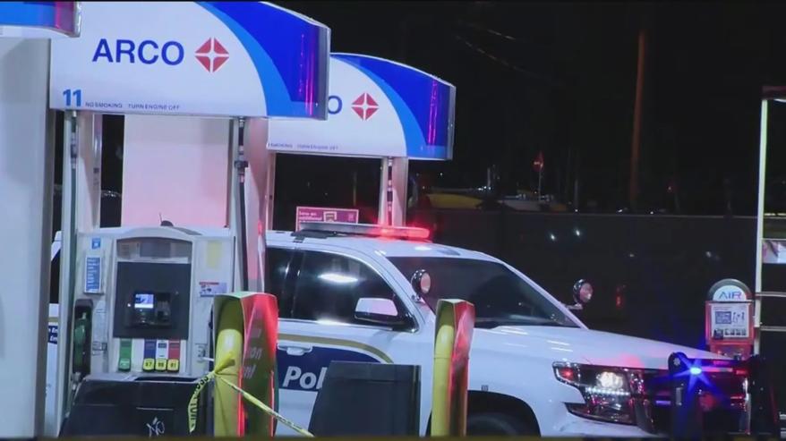 A picture of police cars sectioning off a gas station after a shooting.