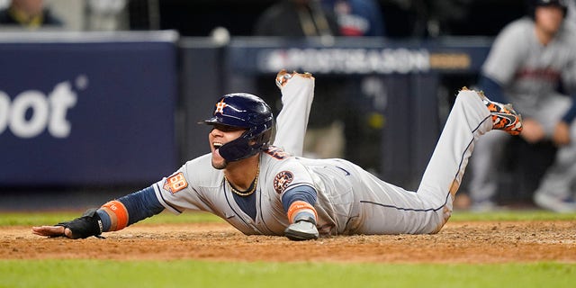 Houston Astros' Yuli Gurriel reacts as he slides home safely to score against the New York Yankees during the sixth inning of Game 3 of an American League Championship baseball series, Saturday, Oct. 22, 2022, in New York. 