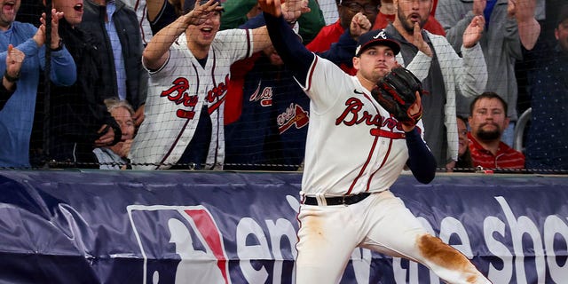 Austin Riley #27 of the Atlanta Braves throws the ball after making a catch against the Philadelphia Phillies during the eighth inning in game two of the National League Division Series at Truist Park on October 12, 2022 in Atlanta, Georgia.