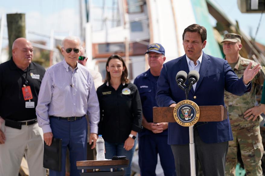 President Biden listens as DeSantis speaks.