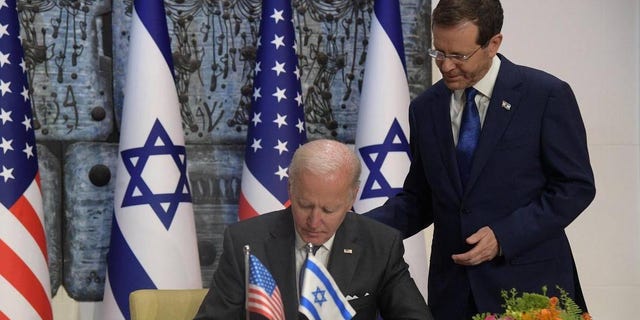 U.S. President Biden signs the guestbook before talks with Israel's President Isaac Herzog at the presidential office in West Jerusalem, on July 14, 2022.