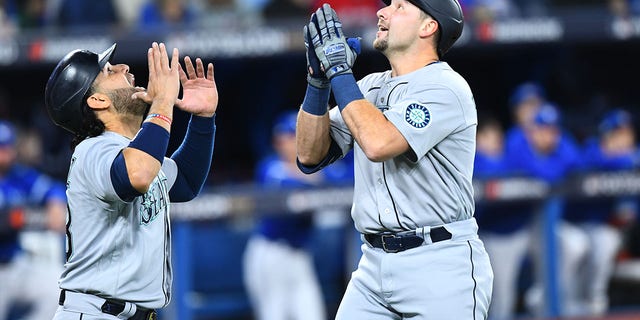 Seattle Mariners catcher Cal Raleigh, right, celebrates a home run with infielder Eugenio Suarez during the first inning of wild-card Game 1 against the Toronto Blue Jays Oct. 7, 2022, at Rogers Centre in Toronto. 