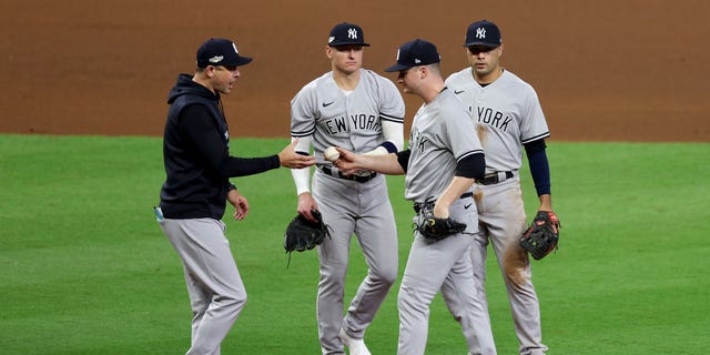 Aaron Boone #17 of the New York Yankees takes Clarke Schmidt #86 out of the game during the sixth inning against the Houston Astros in game one of the American League Championship Series at Minute Maid Park on October 19, 2022 in Houston, Texas.