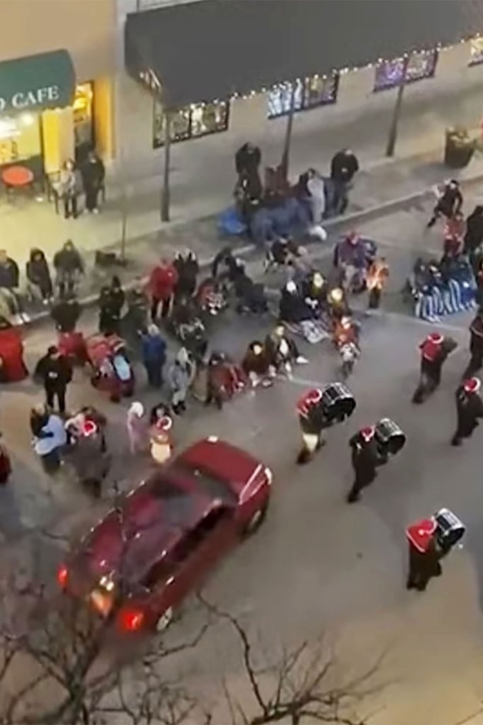 A SUV drives through a Christmas parade