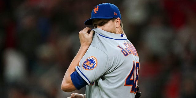 New York Mets starting pitcher Jacob deGrom wipes his face after allowing a solo home run to Atlanta Braves' Matt Olson during the second inning of a baseball game Friday, Sept. 30, 2022, in Atlanta.