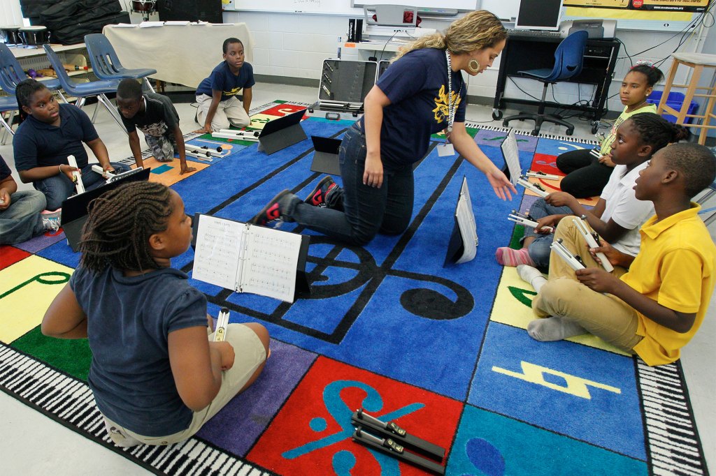 During a mandatory after-school program, Potter Elementary School music teacher Lindsay Blanc. center, gets a group of fourth grade students ready to play "Simple Gifts" in the school chime ensemble, on May 24, 2013, in Tampa, Fla.