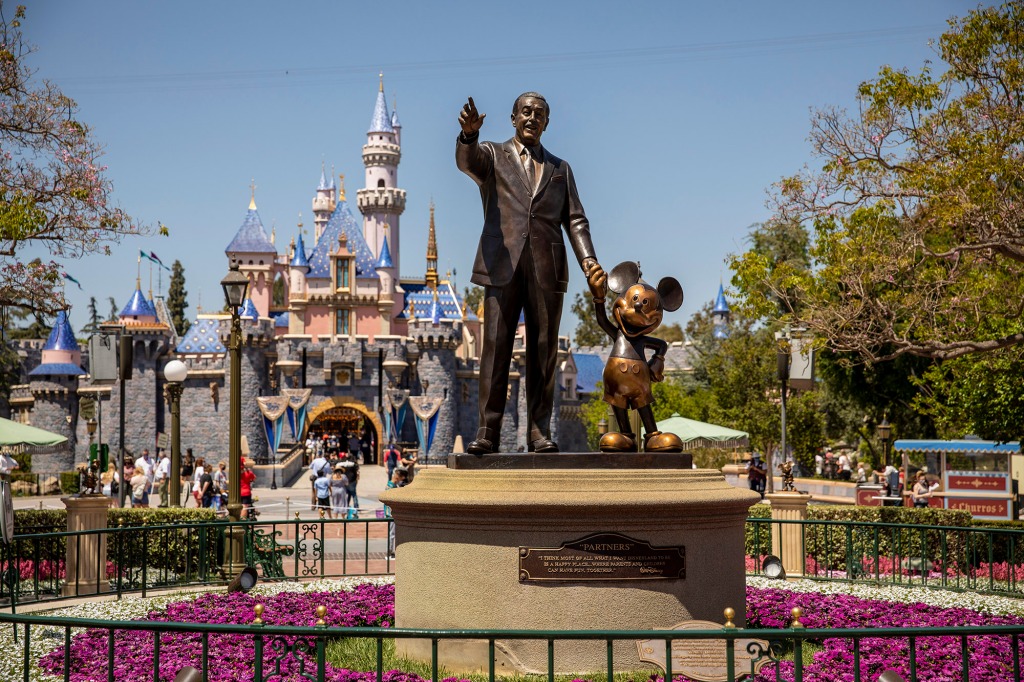 The icon statue of Walt Disney holding hands with Mickey Mouse is seen at the end of Main Street, with Sleeping Beautys castle behind, at Disneyland in Anaheim, CA, 