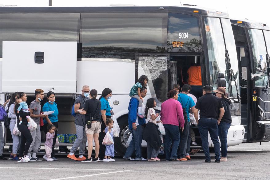 Asylum-seeking migrants lining up for a bus outside the Migrant Welcome Center in El Paso, Texas on October 16, 2022.