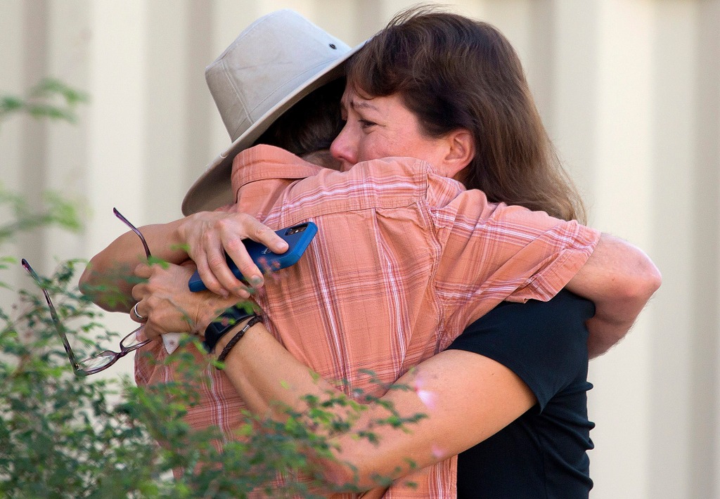 two people embrace after shooting at UA