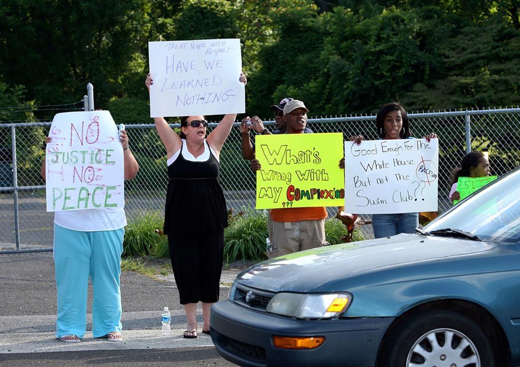 Protestors demonstrate in front of the Valley Club in Huntingdon Valley, Pa., alongside other supporters in response to allegations that the swim club blocked a group of minority children from joining weekly swims at the pool, Thursday, July 9, 2009.