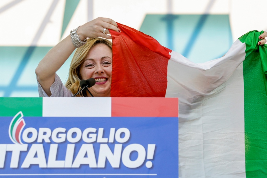 Giorgia Meloni holds an Italian flag as she addresses a rally in Rome, Saturday, Oct. 19, 2019. 