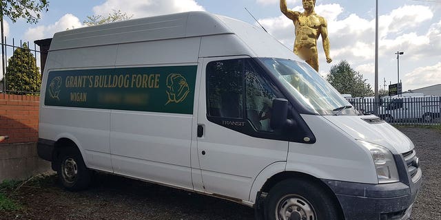 Wigan's golden statue is seen behind a local store's bus prior to its removal on advice of the town council.