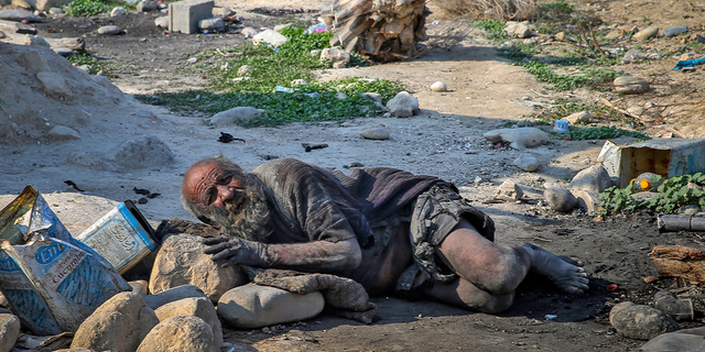 Amou Haji lies on the ground on the outskirts of the village of Dezhgah, Iran, on Dec. 28, 2018.