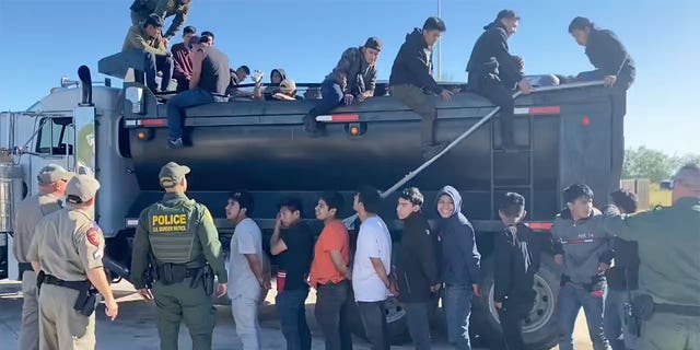 Illegal immigrants in a single file line after driver is busted by DPS officers.