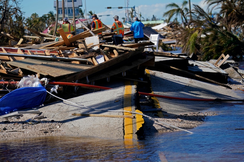 Responders from the de Moya Group survey damage to the bridge leading to Pine Island, to start building temporary access to the island in the aftermath of Hurricane Ian in Matlacha, Fla., Sunday, Oct. 2, 2022. 