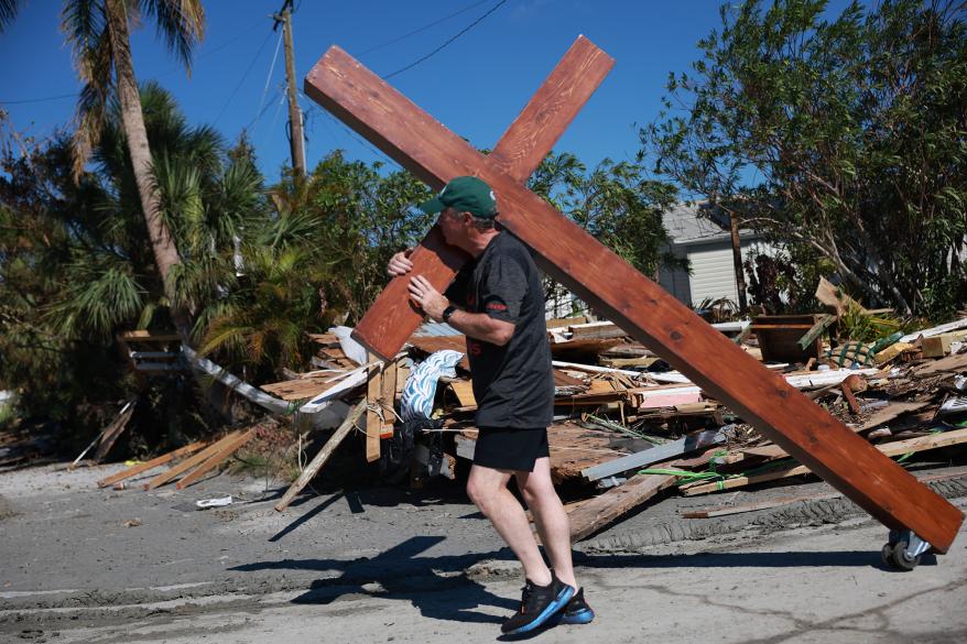Dan Beazley rolls a cross through an area where homes were destroyed when Hurricane Ian passed through the area on October 1, 2022 in Fort Myers, Florida.