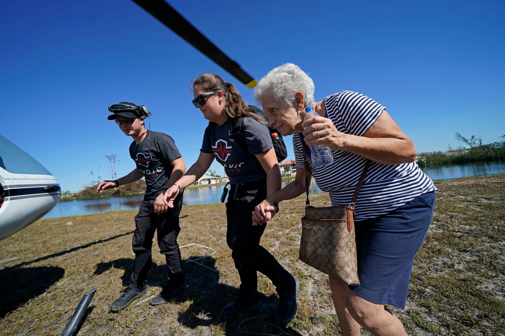 Members of mediccorps.org help evacuate Bria Acerbo in the aftermath of Hurricane Ian on Pine Island, Fla., Saturday, Oct. 1, 2022.