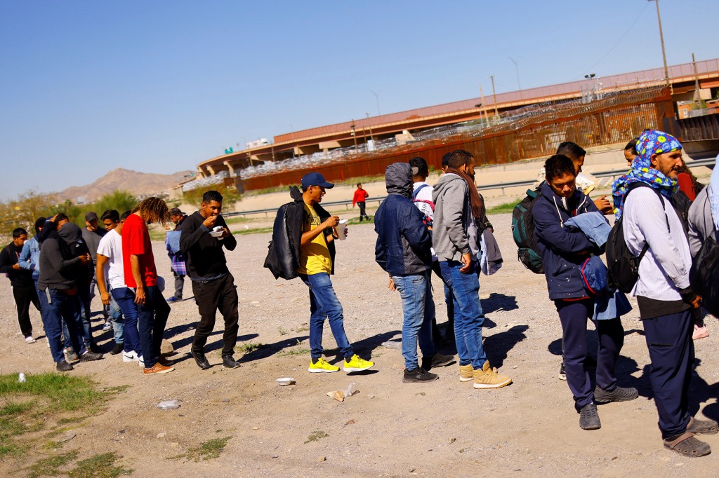 Venezuelan migrants, some expelled from the U.S. to Mexico under Title 42 and others who have not yet crossed, queue to receive donated food from members of a Christian church near the Paso del Norte International border bridge, in Ciudad Juarez, Mexico October 20, 2022. 