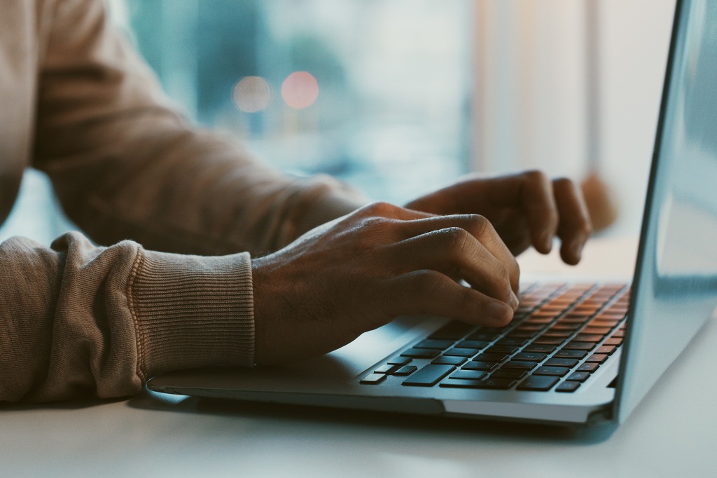 A picture of a person typing on their computer.