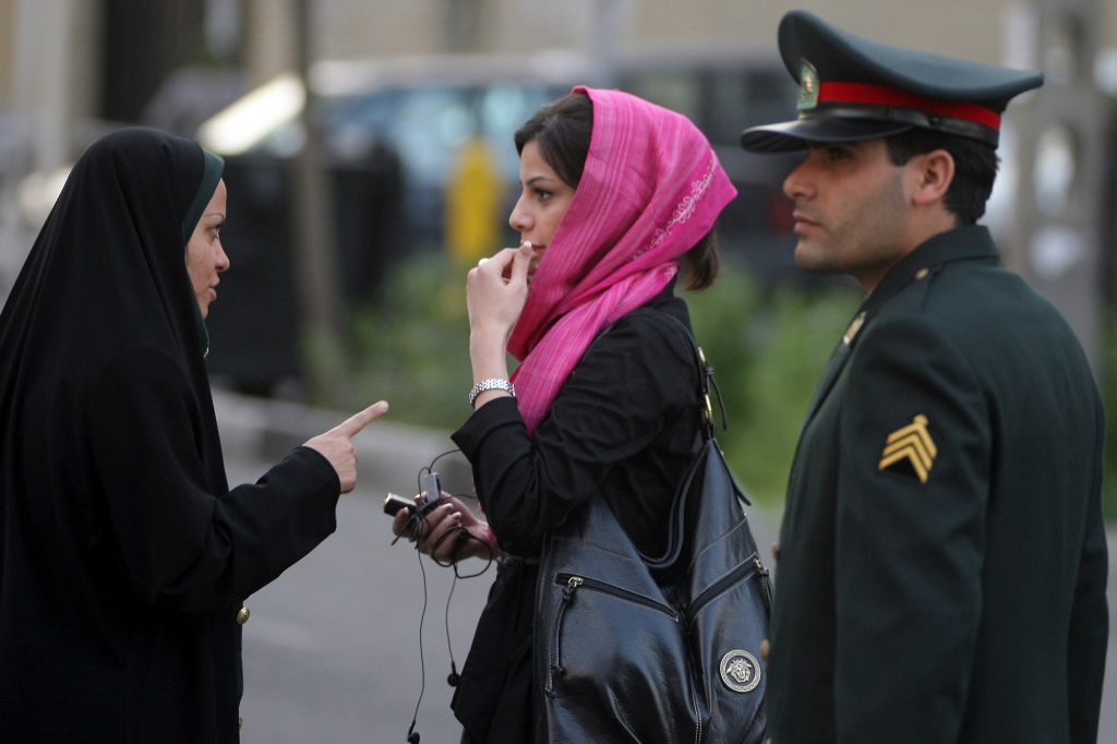 An Iranian policewoman (L) warns a woman about her clothing and hair during a crackdown to enforce Islamic dress code on April 22, 2007 in Tehran, Iran.