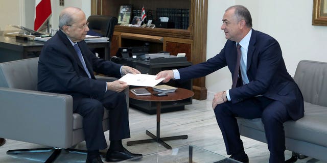 In this photo released by Lebanon's official government photographer Dalati Nohra, Lebanese President Michel Aoun, left, receives the final draft of the maritime border agreement between Lebanon and Israel from the deputy of Lebanese prime minister Elias Bou Saab and who leads the Lebanese negotiations, in Beirut, Lebanon, Tuesday, Oct. 11, 2022.