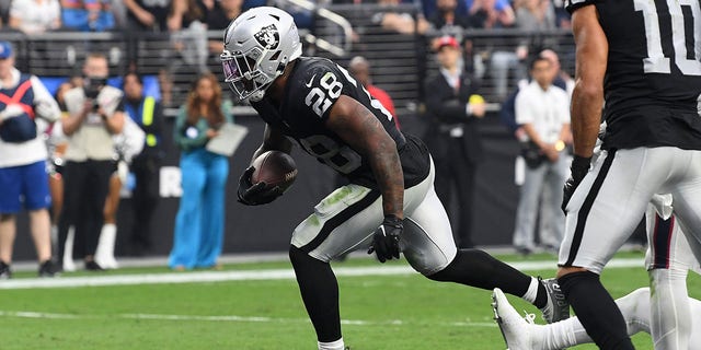 Josh Jacobs #28 of the Las Vegas Raiders carries the ball in for a touchdown in the fourth quarter against the Houston Texans at Allegiant Stadium on October 23, 2022 in Las Vegas, Nevada. 