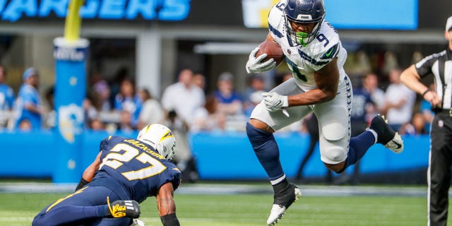 Seattle Seahawks running back Kenneth Walker III eludes the tackle of Los Angeles Chargers cornerback J.C. Jackson (27) at SoFi Stadium.