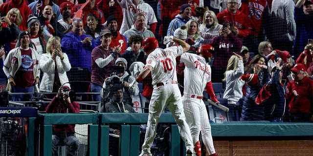  J.T. Realmuto #10 and Bryce Harper #3 of the Philadelphia Phillies celebrate a solo home run by Realmuto during the seventh inning of Padres in game four of the National League Championship Series at Citizens Bank Park on October 22, 2022 in Philadelphia, Pennsylvania.