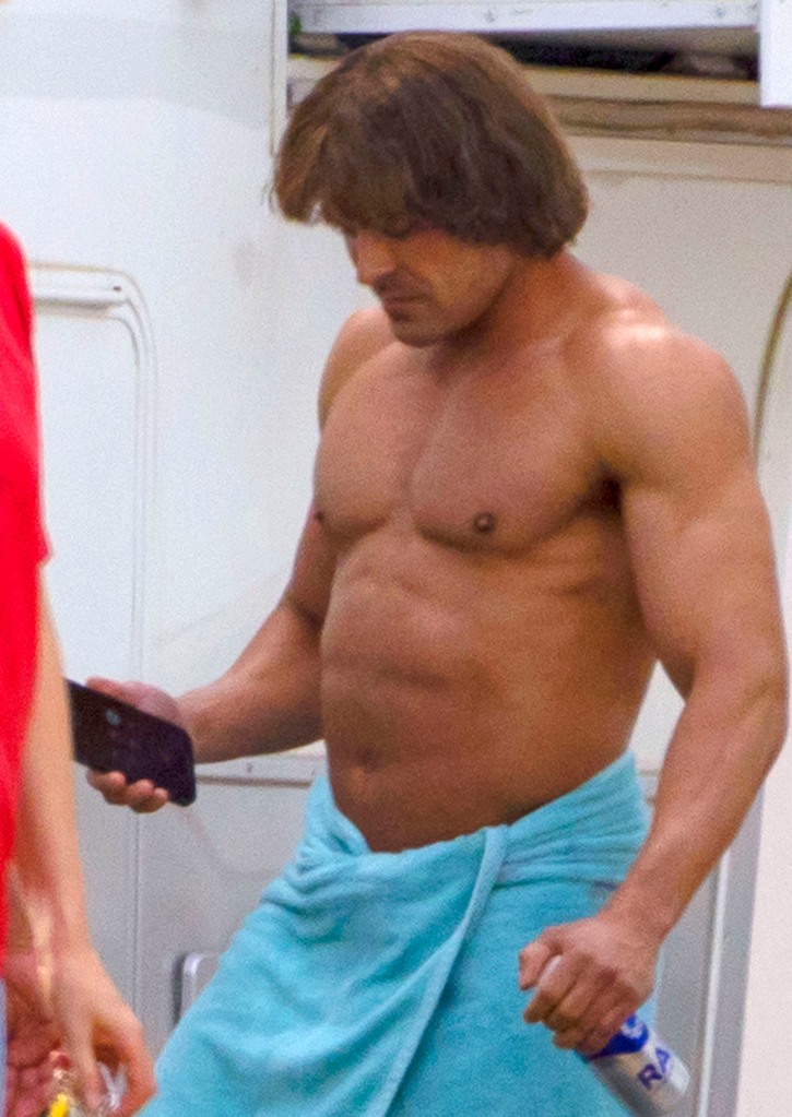 Sporting a six pack and a deep bronze tan, the musclebound actor looked worlds away from his fresh-faced  High School Musical  days as he stepped out of his trailer on set in Louisiana. He was completely unrecognizable after undergoing a dramatic body transformation for the new role, wearing a brown wig and wrapping his taut torso in a skimpy blue towel. At one point, he could be seen adjusting his privates as he prepared to film swimming scenes for the hotly-anticipated movie, which features an all-star cast including Harris Dickinson, Holt McCallany, Jeremy Allen White and Maura Tierney. Based on the true story of the Von Erichs, the film follows the rise and fall of the family dynasty of wrestlers who made a huge impact on the sport from the 1960s to the present day. In between scenes, 35-year-old Efron sipped from an aluminum bottle of Rain, a plastic free natural spring water.
