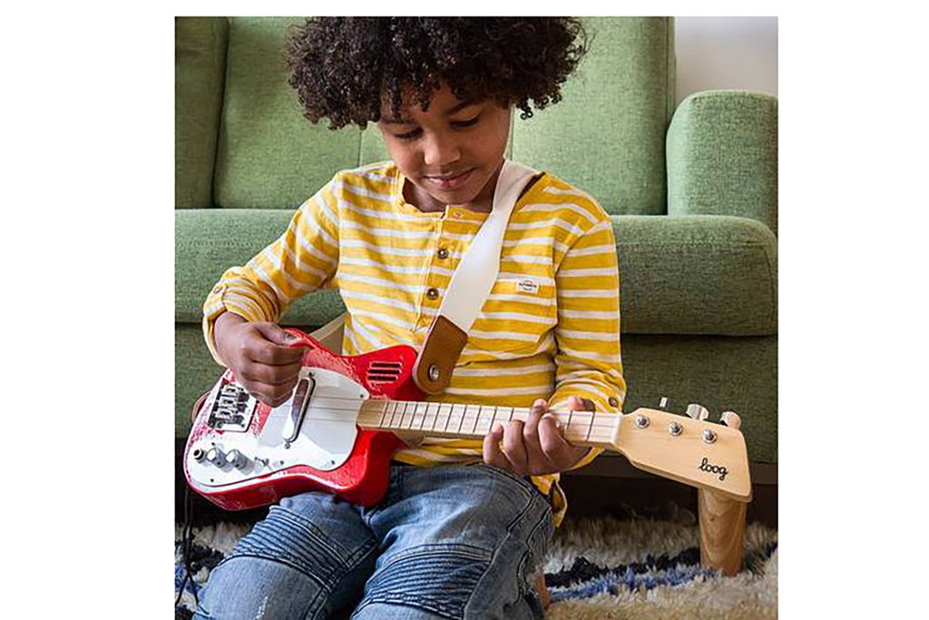 A child playing a mini red electric guitar 