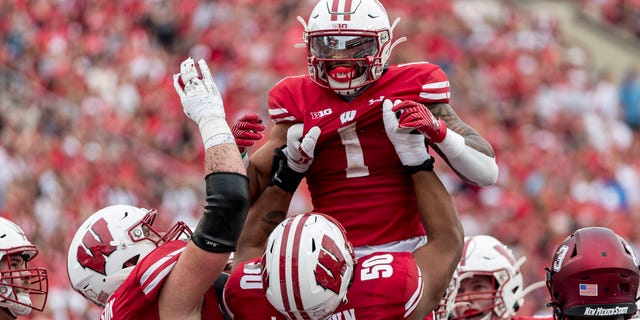 Wisconsin Badgers offensive lineman Logan Brown (50) lifts up Wisconsin Badgers running back Chez Mellusi (1) in celebration of a touchdown run durning a college football game between the New Mexico State Aggies and the Wisconsin Badgers on September 17th, 2022 at Barry Alvarez field in Camp Randall Stadium in Madison, WI.